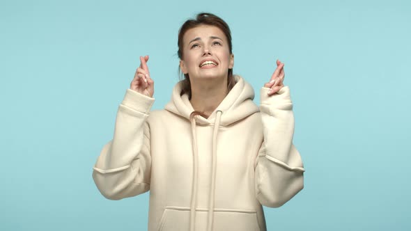 Slow Motion of Young Woman in Hoodie Looking Nervous Cross Fingers and Begging God Pleading for Wish alt