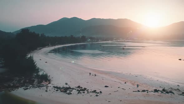 Aerial View Sunset Over Sandy Beach and Sea Mountains with Trees Golden Hour alt