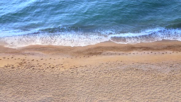 View of the sea waves on the beach. Yellow sand and blue water alt