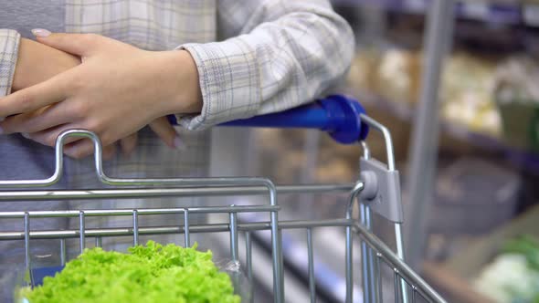 Woman Pushing Shopping Trolley Walking in Supermarket