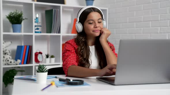 Happy Kid Typing on Laptop at Online School Lesson in Earphones Modern Life