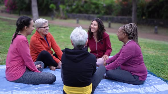 Happy multi generational women having fun talking at park outdoor - Multiracial people enjoy day