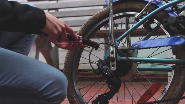 Man inflating the flat tire of the bicycle alt