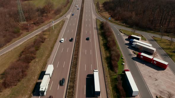 Tilt Up Reveal of Straight Highway Leading in Flat Countryside Between Fields alt