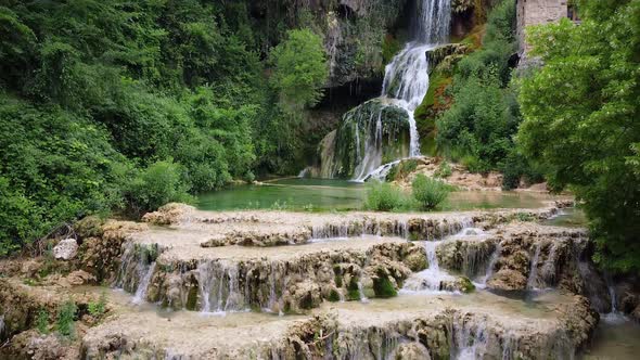 Cinematic Aerial Shot of an Idyllic Waterfall in a Medieval Village, Orbaneja Del Castillo. Famous alt