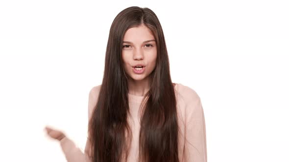 Portrait of Cunning Young Woman with Long Dark Hair Holding Index Finger on Lips Asking to Keep alt