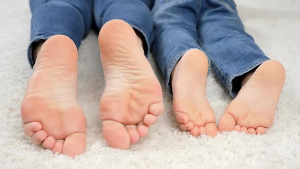 CLoseup of Parent and Child Moving on Floor at Home and Moving Bare Feet alt