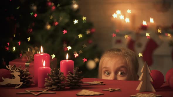 Girl Looking Out Table Decorated for Christmas Celebration, Festive Atmosphere alt