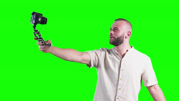 Young Smiling Vlogger Holding Camera on Tripod and Filming Video