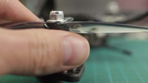 Extreme Close Up of Young Man's Hands Assembling FPV Racing Drone. Removing Propeller