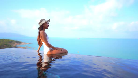 Young asian woman enjoy around outdoor swimming pool for leisure alt