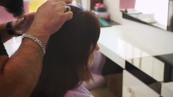 Hands of Hairdresser Smooth Hair on Head of Young Girl