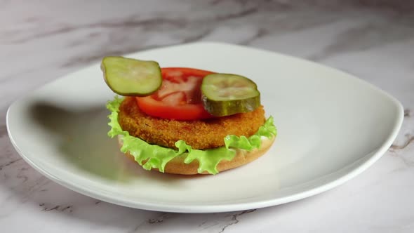 Two Slices of Pickled Cucumber Fall on an Unfinished Burger