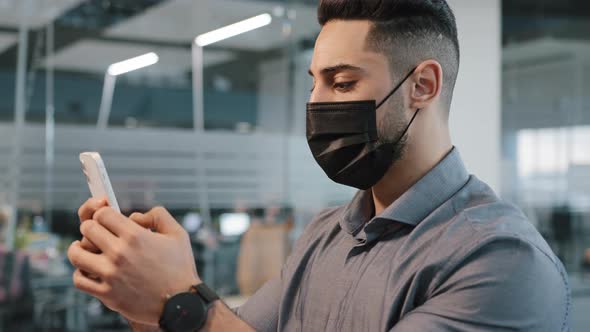 Multiracial Arab Man Guy in Shirt Wear Medical Face Protective Mask in Office Chatting Texting in alt