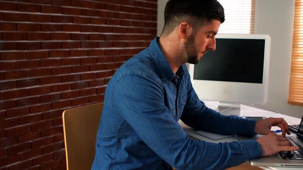 Male graphic designer using laptop alt