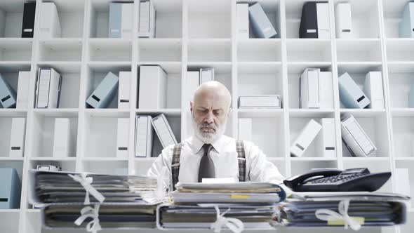 Senior businessman folding and launching a paper airplane