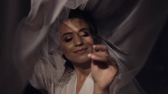 Bride in Boudoir Dress Under Veil and in a Silk Robe Wedding Morning Preparations Before Ceremony alt