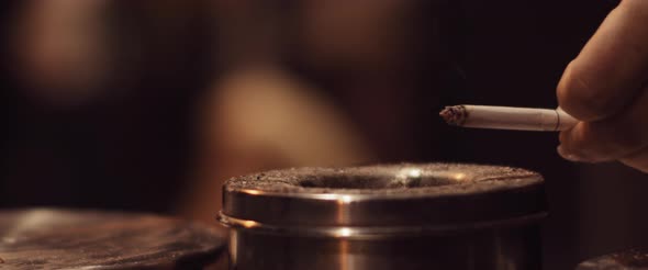Woman drops ash of a cigarette into the ashtray, beautiful wisp of smoke alt