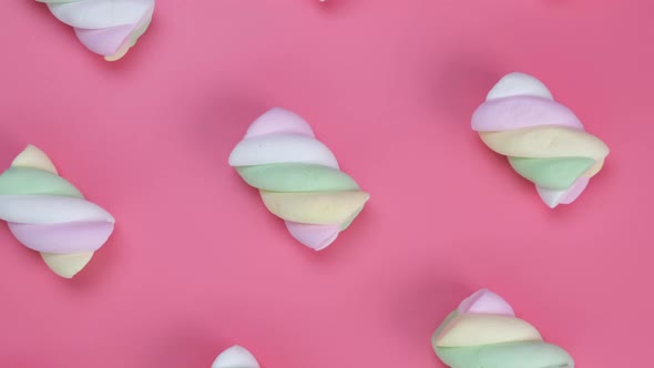 Rotating Multicolored Chewy Marshmallows on a Pink Background the Concept of a Birthday Holiday Fun