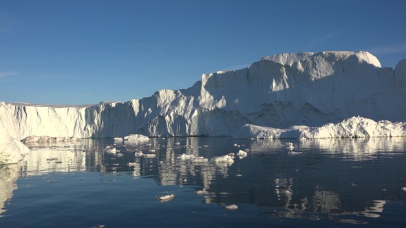 Ilulissat, Greenland. Massive icebergs floating near the shores of a glacier. alt