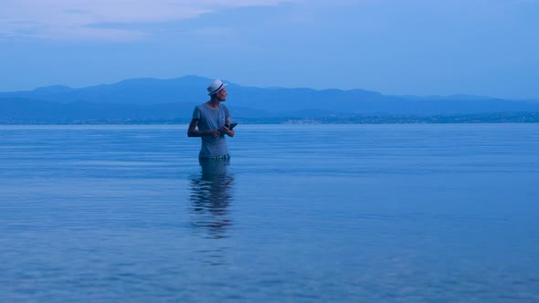 Hipster with Notebook on Sunset Background. Freelancer Working on the Nature. Distant Job Background alt