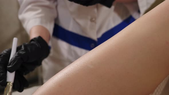Beautician Applies Transparent Gel on Female Leg Before Hair Removal alt