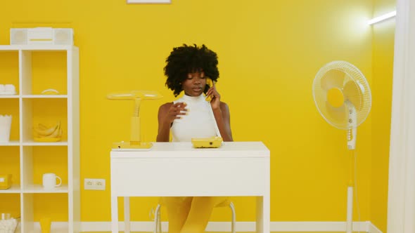 Woman Has Phone Talk In YellowandWhite Office alt