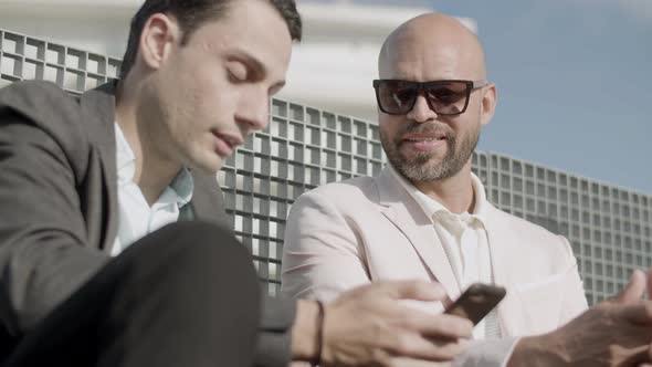 Closeup of Business Partners Looking at Phone Screen Outdoor