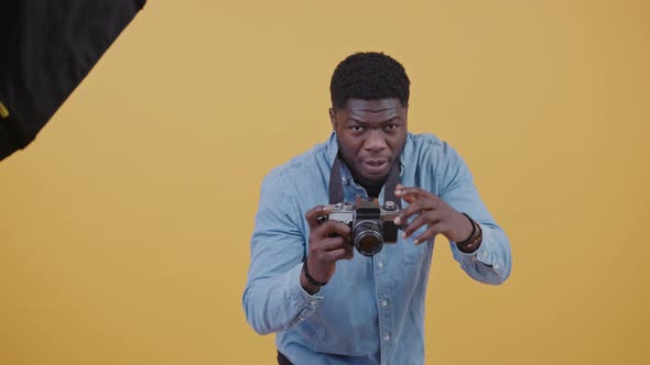 Handsome African American Photographer at Work in Studio Horizontal Video Yellow Background Copy alt