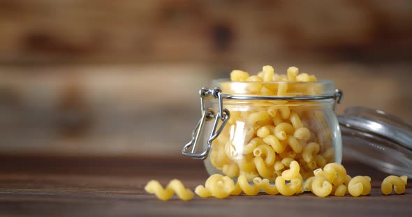 Pasta Dry Cavatappi in a Glass Jar Rotates Slowly.  alt