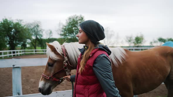 Young Jockey Taking Her Brown Horse With A Blonde Mane For A Ride During Daytime alt