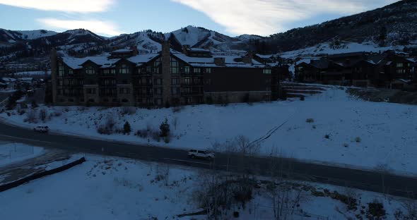 Aerial profile tracking shot of truck as it drives away from park city resort alt