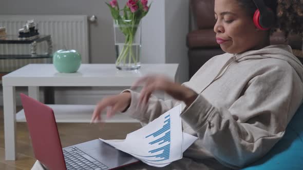 Overburdened Tattooed African American Woman Sticking Tongue Out Analyzing Graphs and Typing on alt