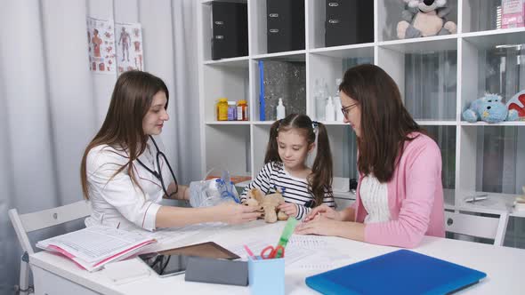 Mother Supports and Soothes Little Daughter in the Doctor's Office Until Her Daughter Ingaliruut By