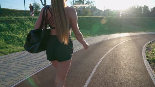 Young Fit Woman Carrying Bag at Stadium alt