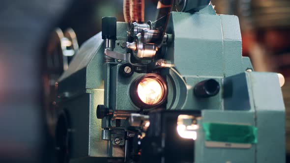Old Film Projector is Demonstrating a Tape Movie alt