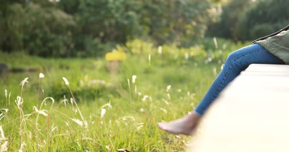 Woman sitting at the wooden walkway in countryside alt