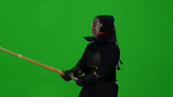 Masculine Kendo Warrior Practicing Martial Art with the Bamboo Bokken on Green Screen. CLose Up alt