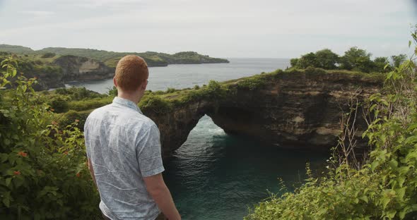 Close Up View of a Man with Ginger Hair on the Cliff Overlooking the Broken Beach on Nusa Penida in alt