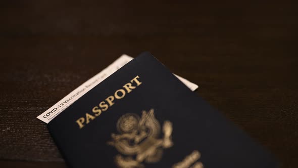 Covid-19 CDC vaccination paper hanging out of the top of a U.S. passport alt