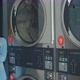 Woman Using Smartphone While Washing Her Laundry at Laundromat. - VideoHive Item for Sale