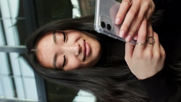 Portrait Of An Korean Girl With Mobile Phone In Her Hands alt