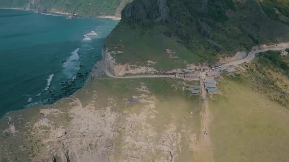 Cinematic aerial drone video of splashing ocean waves into a scenic mountains of Sabtang, Batanes in alt