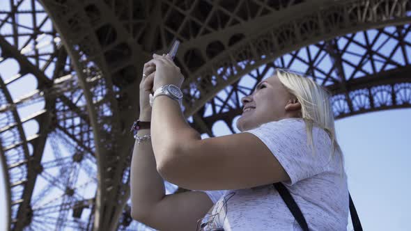 Happy Woman Making Video Call Under Eiffel Tower alt