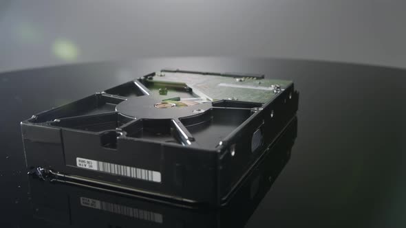 Close up studio shot of a hard drive rotating on reflective surface