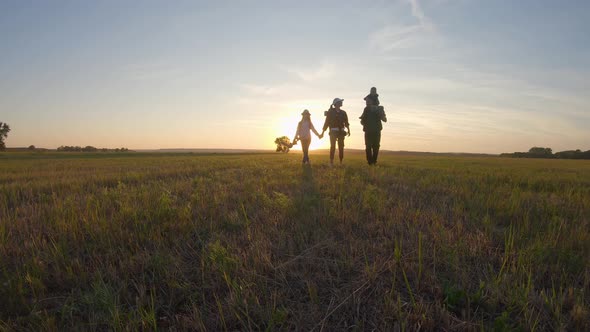 Father, Mother and Children Hiking. Baby Sits on the Shoulders of His Father. Hiking Backpackers alt