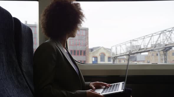 Afro American businesswoman working on laptop whilst on her commute 