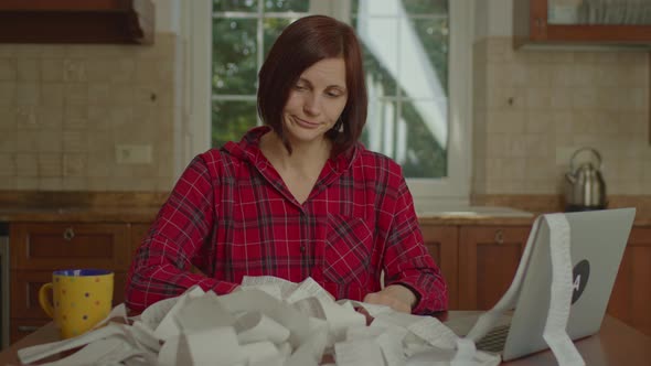 Young Adult Woman Tired of Accounting Family Budget Sitting at the Table in the Kitchen