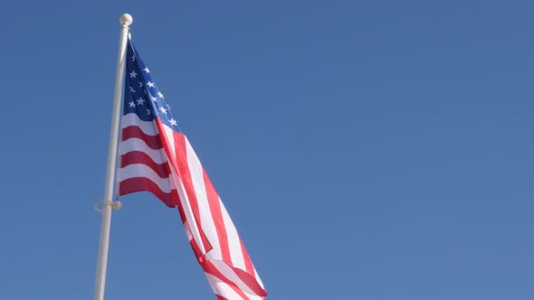 Waving United states of America famous flag in front of blue sky  4K 2160p 30fps UltraHD footage - R