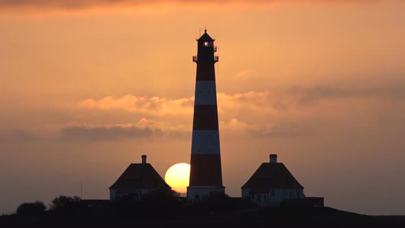 The Big Sun Sets Behind the Lighthouse, Timelapse, Silhouette